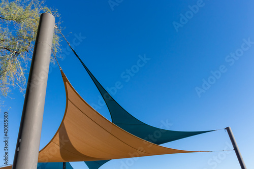 Two sun shade canopies against a clear blue sky used in the Southwest to block the desert sun photo