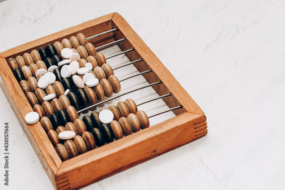Wooden abacus with pills and vitamins on white background. Wooden abacus with pills and vitamins on white background.