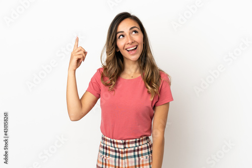 Young woman over isolated background pointing up and surprised