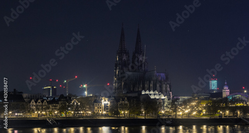 Blick auf den Kölner Dom (Deutschland) mit dem Rhein im Vordergrund in schwarz-weiß