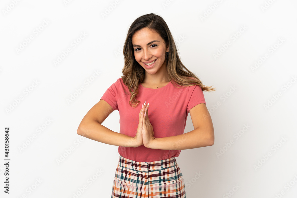 Young woman over isolated background keeps palm together. Person asks for something Young woman over isolated background keeps palm together. Person asks for something