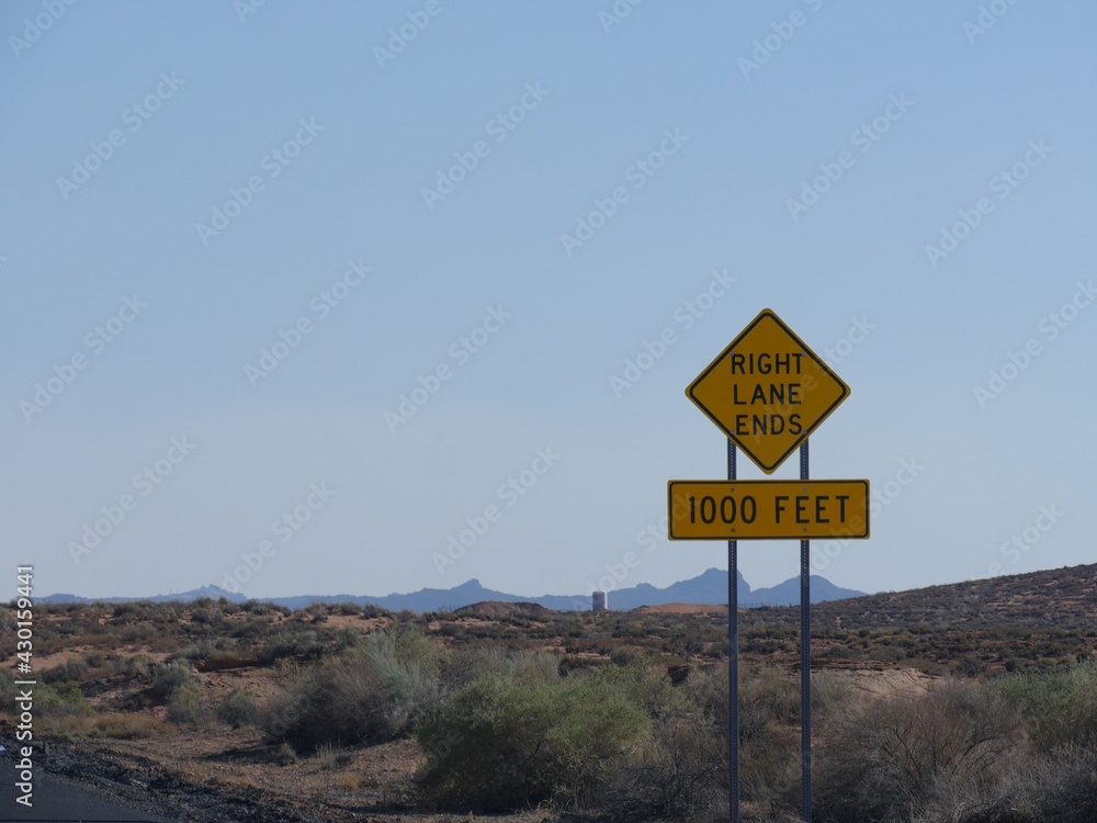 Roadside sign warning drivers the right lane ends in 1000 feet in Arizona.