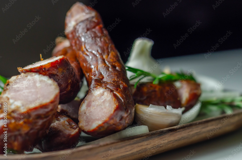 Traditional Polish juniper sausage on a wooden plate, luxury smoked product
