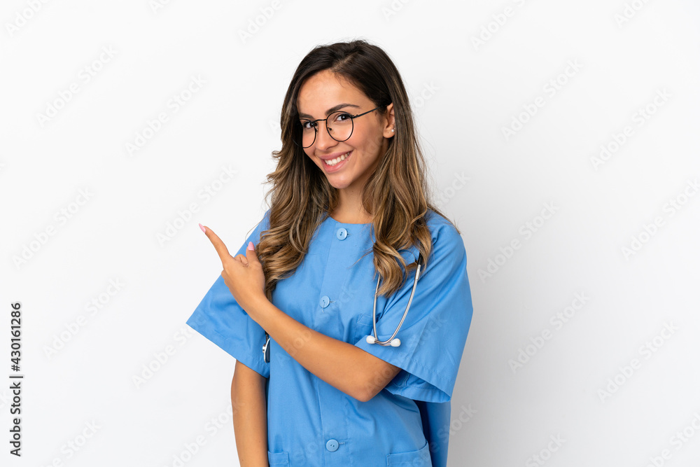 Young surgeon doctor woman over isolated white wall pointing to the side to present a product Young surgeon doctor woman over isolated white wall pointing to the side to present a product