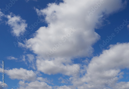 Natural sunny blue sky background with beautiful lush white cumulus clouds and fluffy cirrus clouds