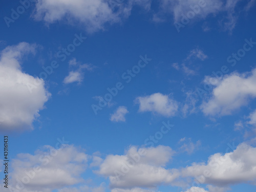 Natural sunny blue sky background with beautiful lush white cumulus clouds and fluffy cirrus clouds