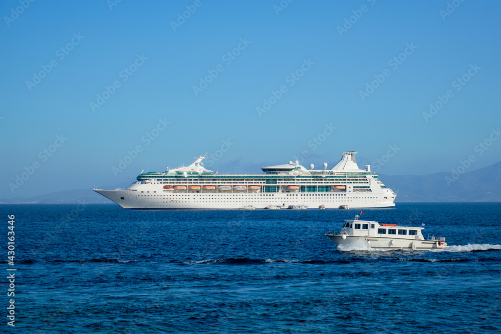 Boat and cruise liner is Aegean sea. Chora, Mykonos island, Greece