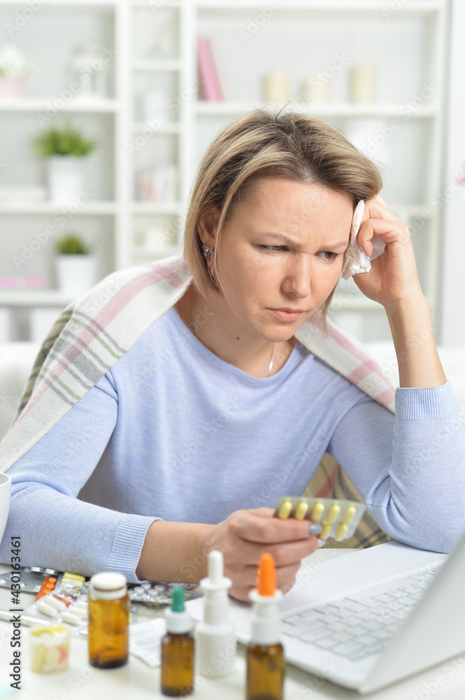 beautiful young woman with pills using laptop