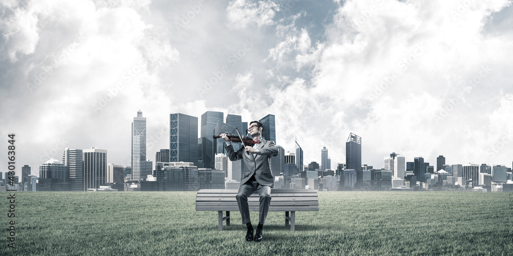Handsome businessman in park on wooden bench play his melody Handsome businessman in park on wooden bench play his melody