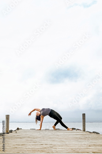 Yoga instructor girl doing Vasisthasana Variation (side plank)