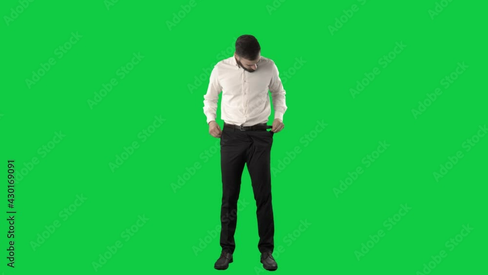 Finance problem. Business man in bankruptcy showing empty pockets. Full length on green screen chroma key background Finance problem. Business man in bankruptcy showing empty pockets. Full length on green screen chroma key background