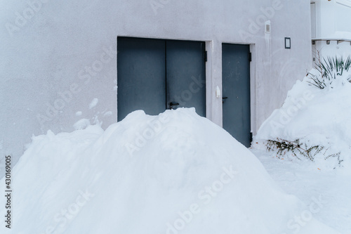huge piles of snow covering doors and gates of houses © kay fochtmann