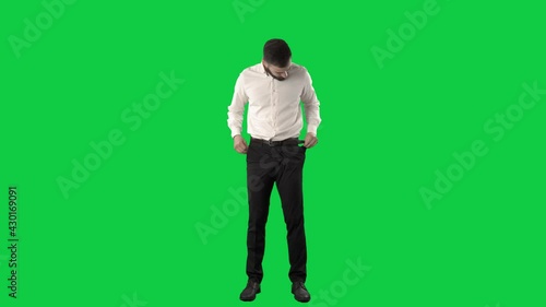 Finance problem. Business man in bankruptcy showing empty pockets. Full length on green screen chroma key background