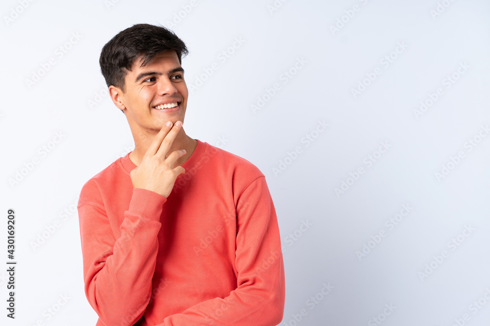 Handsome man over isolated blue background looking up while smiling Handsome man over isolated blue background looking up while smiling
