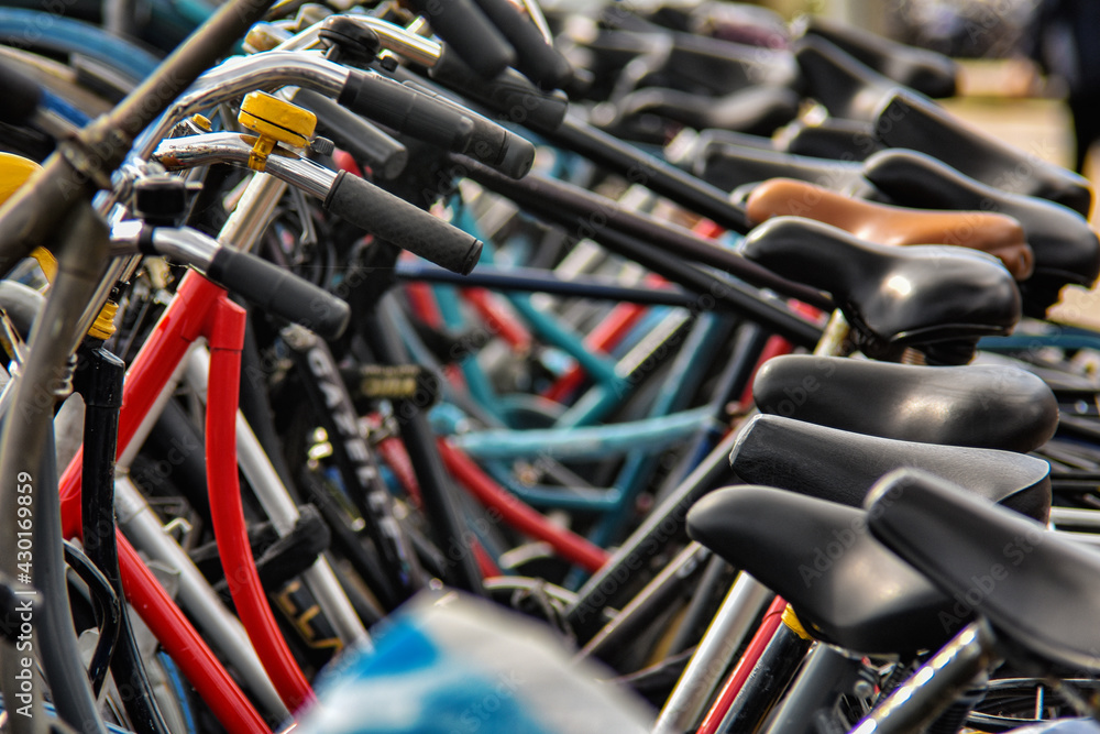 bicycles standing in a row in a parking lot, fragment, blurred image