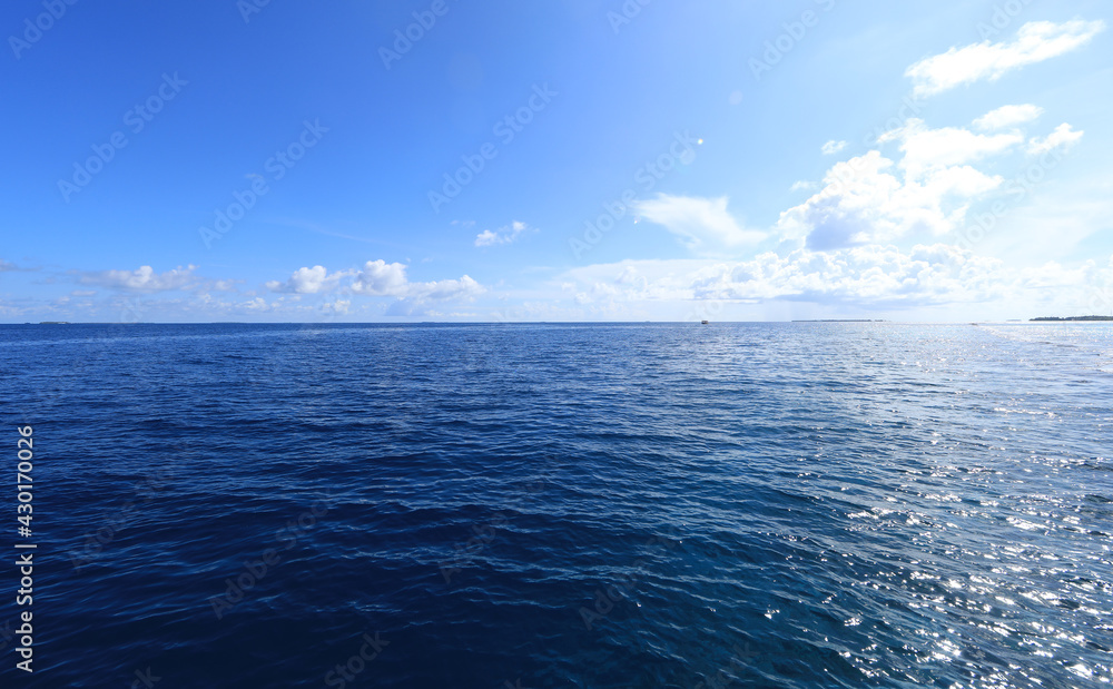 idyllic sunny blue seascape with blue sky and white clouds
