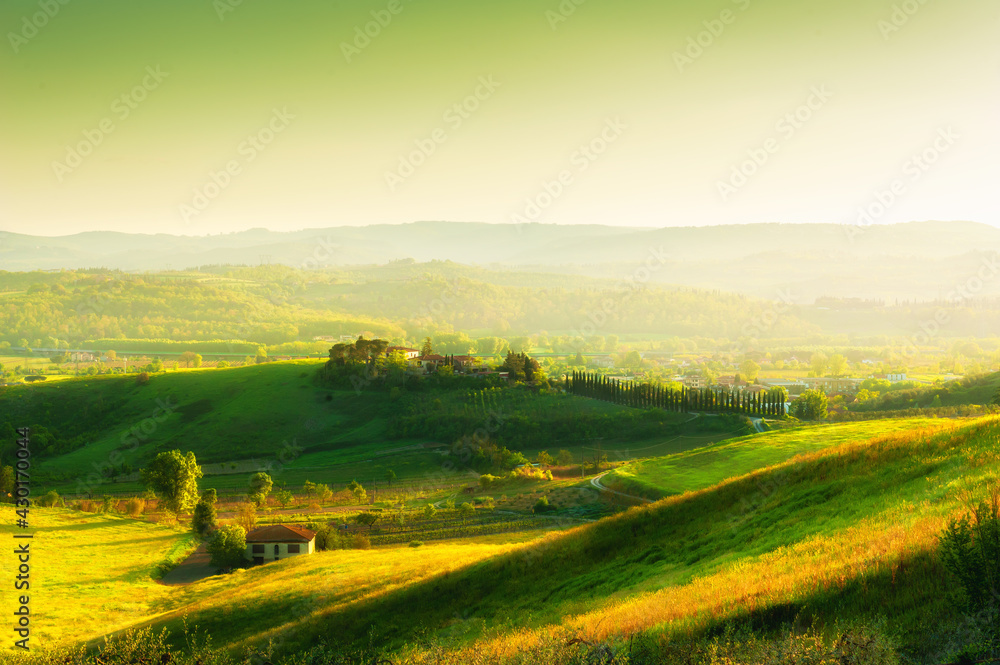 Green hills at sunset in Tuscany, Italy. Beautiful summer landscape. Famous travel destination. Fields with fresh green grass