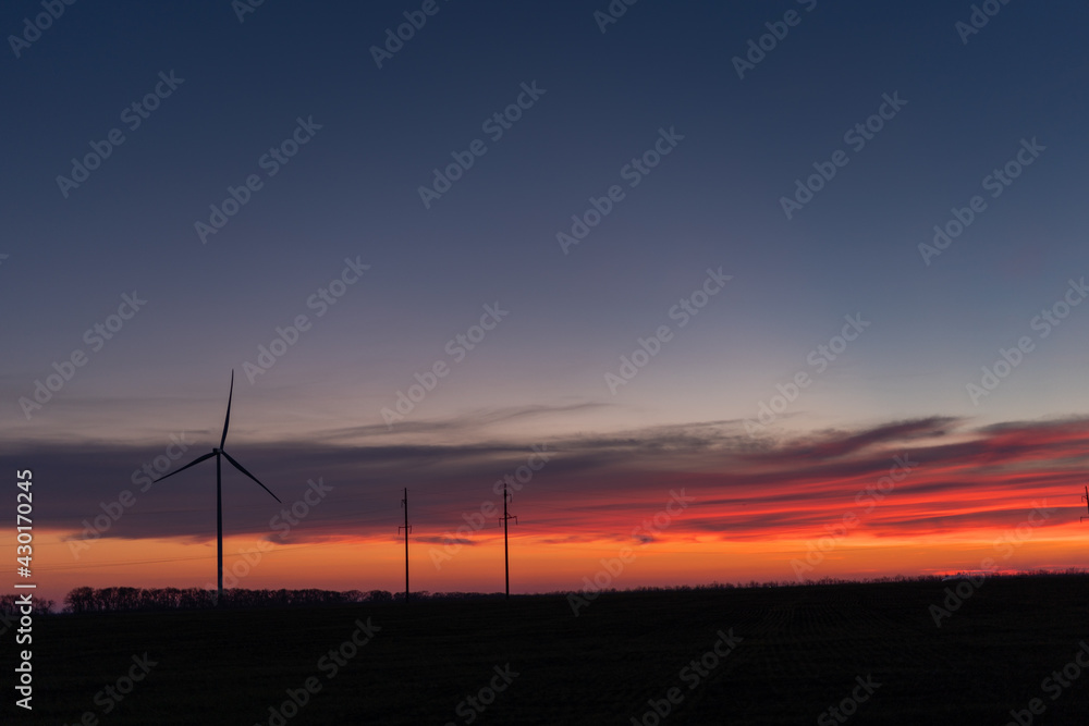 Obraz premium wind generators at sunset, alternative