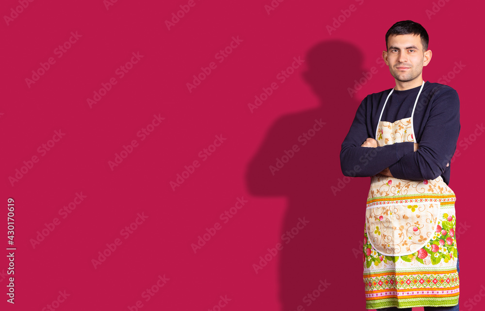 Banner, red background. Caucasian brunette young handsome chef man, in colorful apron crossed arms looking confident at the camera. Plenty space for ad your information text. Man ready to cooking . Banner, red background. Caucasian brunette young handsome chef man, in colorful apron crossed arms looking confident at the camera. Plenty space for ad your information text. Man ready to cooking .
