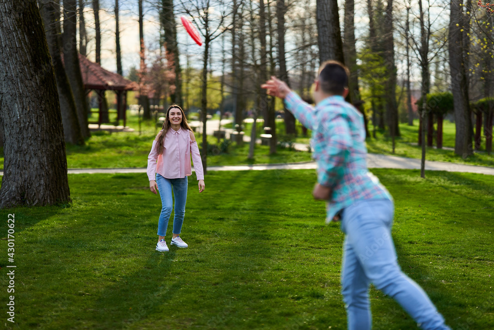 Young couple playing freesbie in the park Young couple playing freesbie in the park