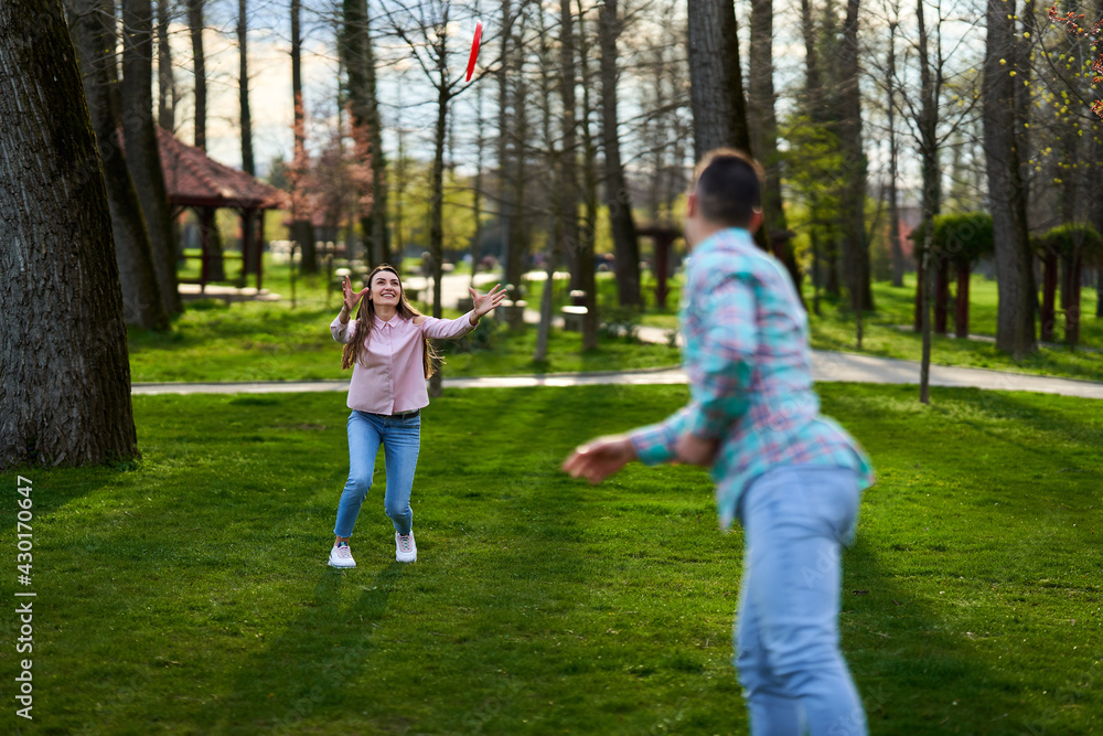 Young couple playing freesbie in the park