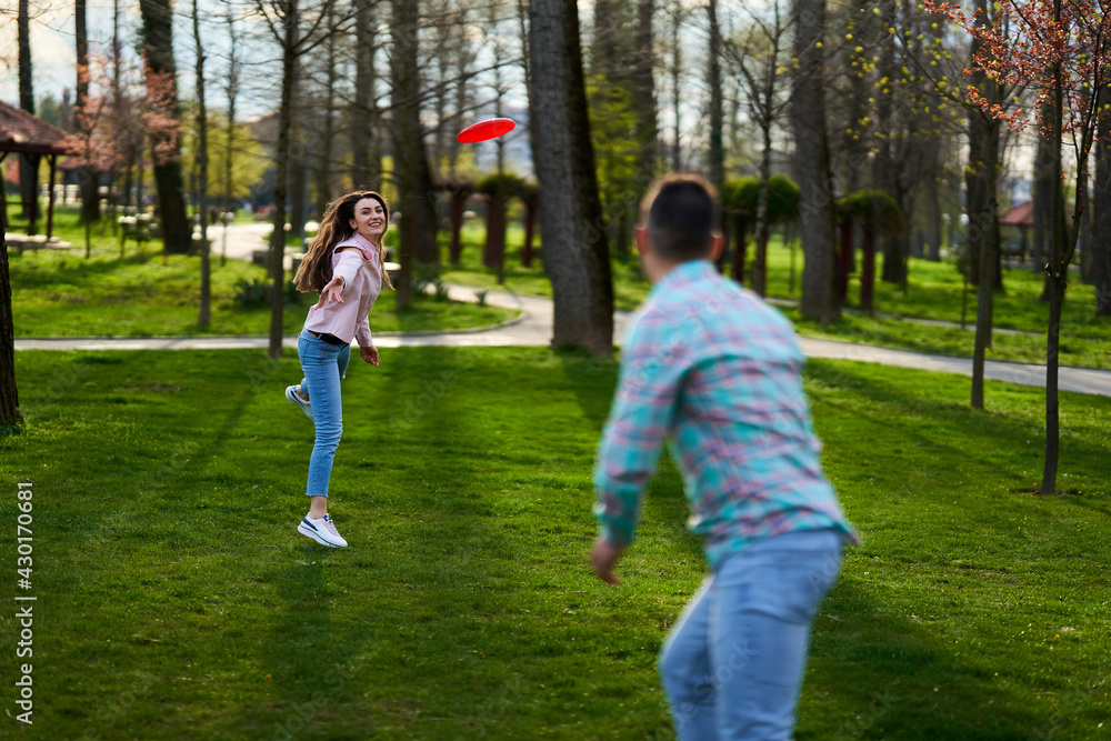 Young couple playing freesbie in the park