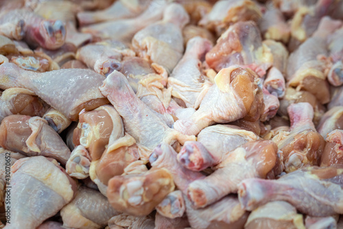 Raw fresh meat of chicken leg (drumstick) selling on local market stall. Raw food and cooking ingredient photo.