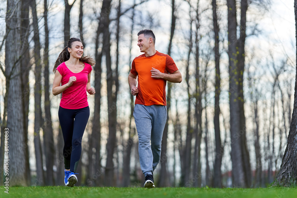Fototapeta premium Young couple running in the park