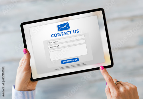 Person writing inquiry on contact form online photo