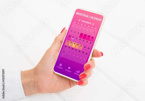 Wallpaper Mural Woman using menstrual calendar app on phone Torontodigital.ca