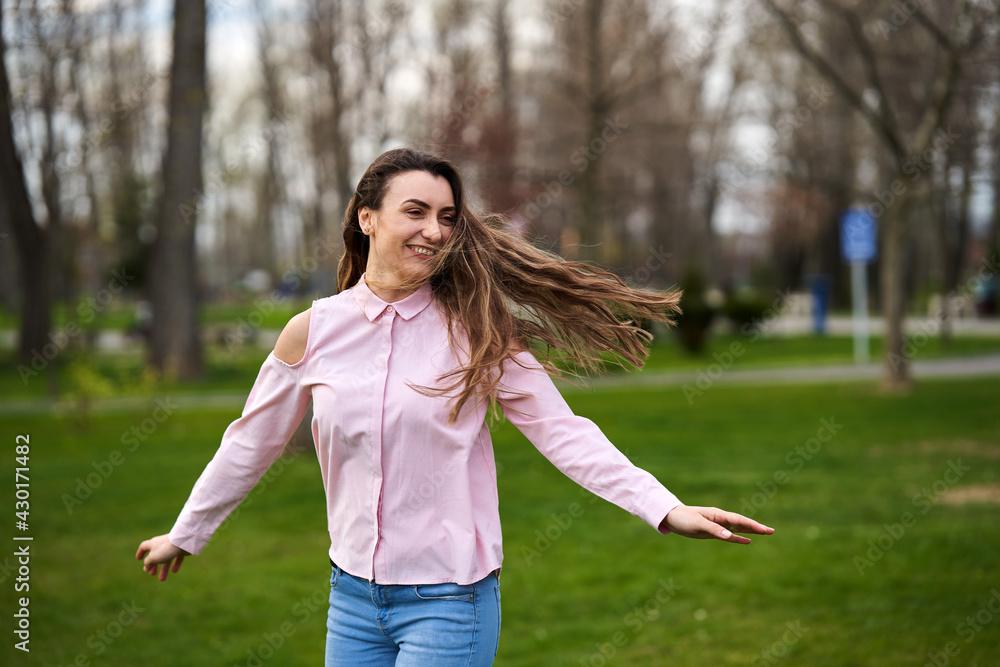 Happy young woman in the park, spinning Happy young woman in the park, spinning