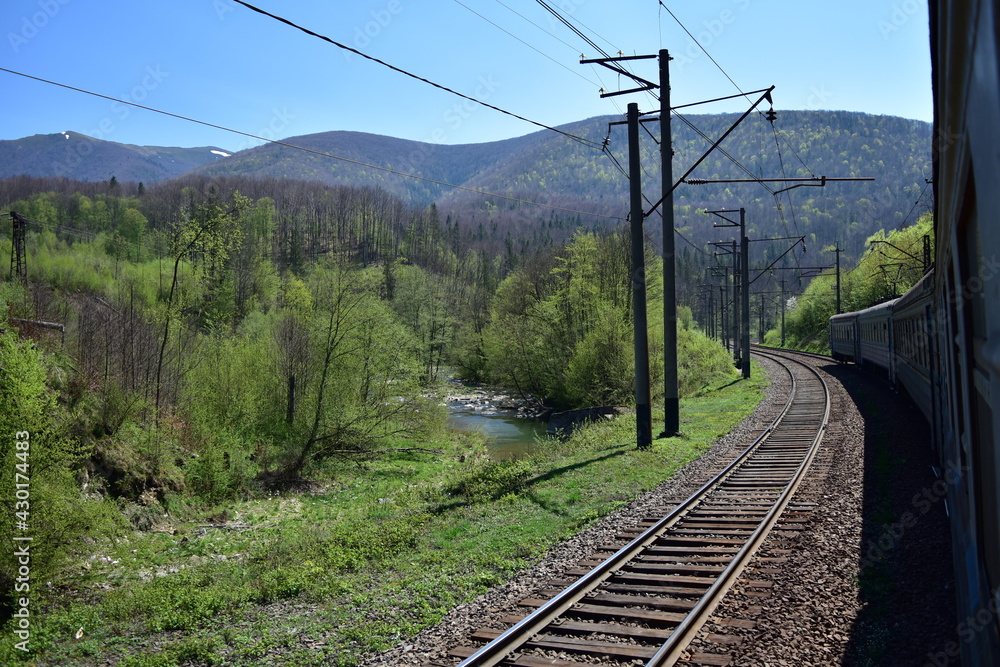 Train and railway line in the 
green scenic mountains