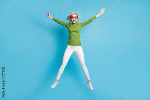 Wallpaper Mural Full size photo of happy excited cheerful smiling girl in glasses jumping in star pose isolated on blue color background Torontodigital.ca