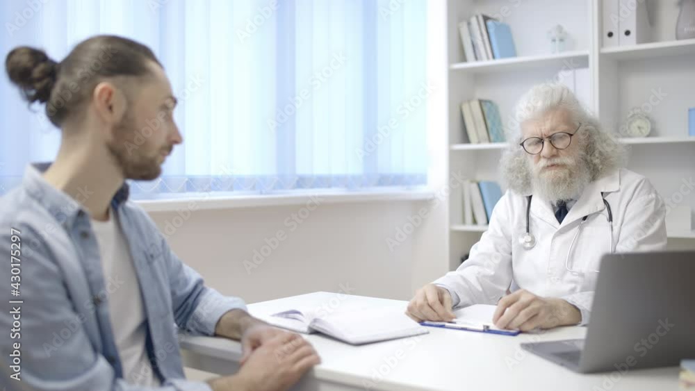 Family physician talking to young male in hospital, visit to the doctor, health Family physician talking to young male in hospital, visit to the doctor, health