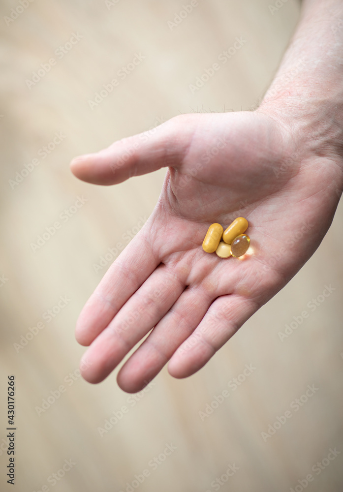 Vitamins and supplements. The man is holding the tablets in his right hand. Pills in hand representing health, help and medicine concept Vitamins and supplements. The man is holding the tablets in his right hand. Pills in hand representing health, help and medicine concept