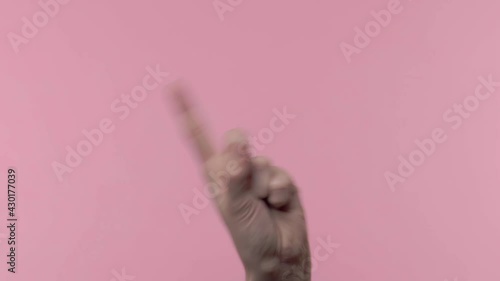 Human hand is making no gesture on pink background