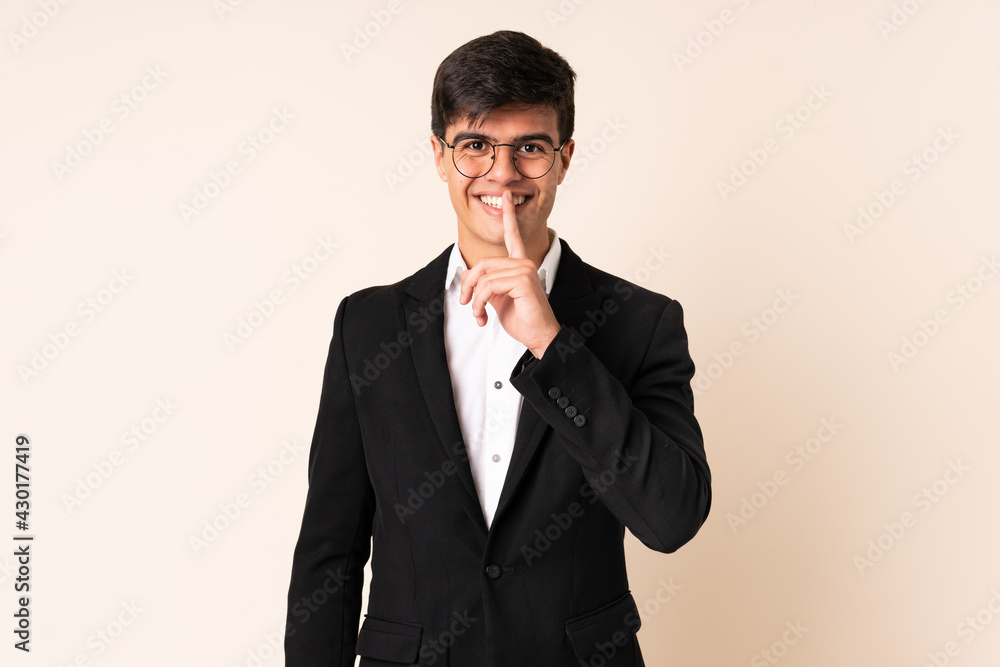 Businessman over isolated beige background doing silence gesture Businessman over isolated beige background doing silence gesture