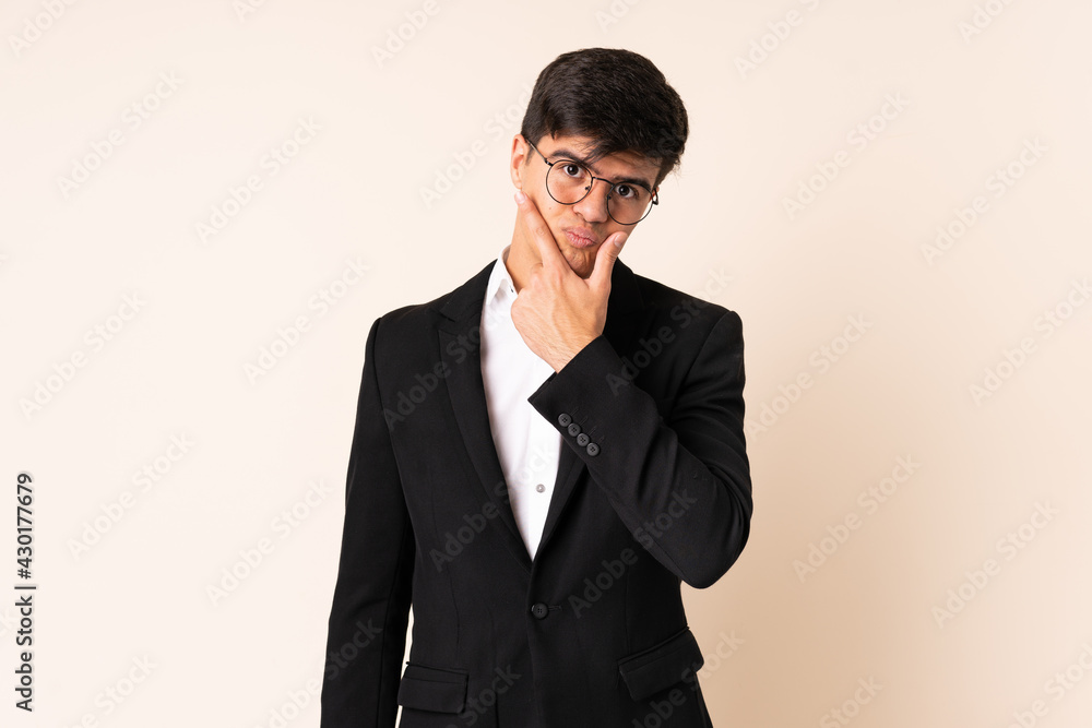 Businessman over isolated beige background thinking an idea Businessman over isolated beige background thinking an idea