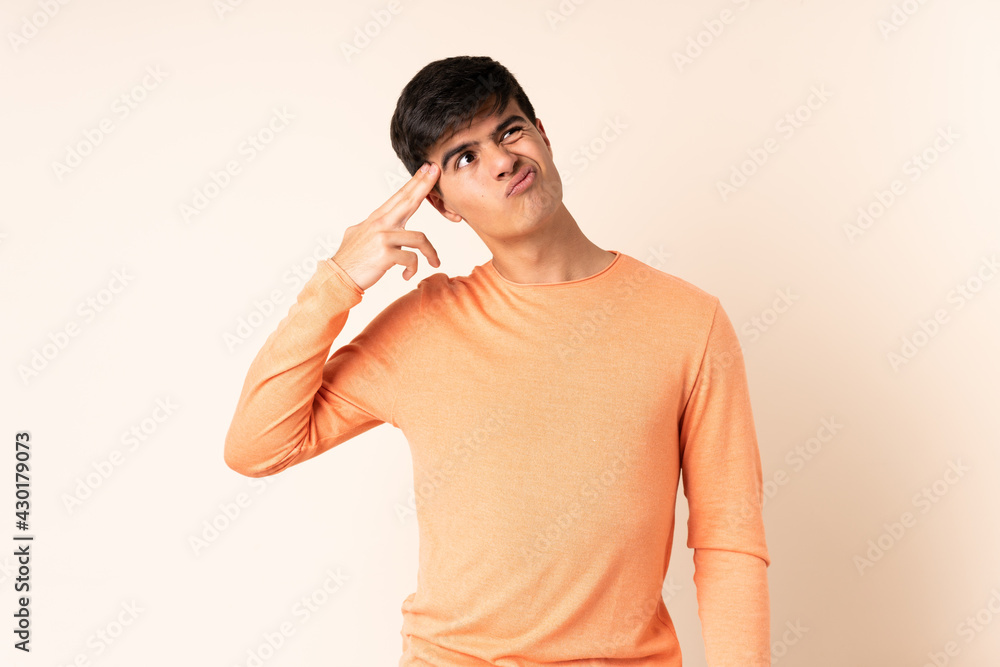 Handsome man over isolated beige background with problems making suicide gesture Handsome man over isolated beige background with problems making suicide gesture