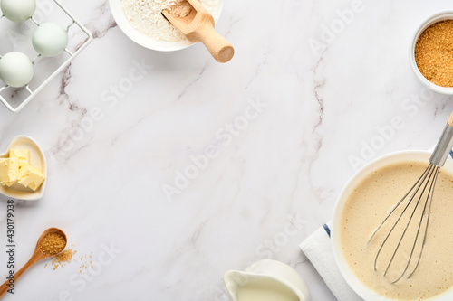 Preparation of dough for home pancakes for Breakfast or for Maslenitsa. Ingredients on the table wheat flour, eggs, butter, sugar, salt, milk. Recipe step by step. Selective focus.