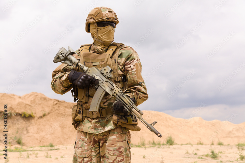 Armed special forces soldier in camouflage holding rifle close-up Armed special forces soldier in camouflage holding rifle close-up