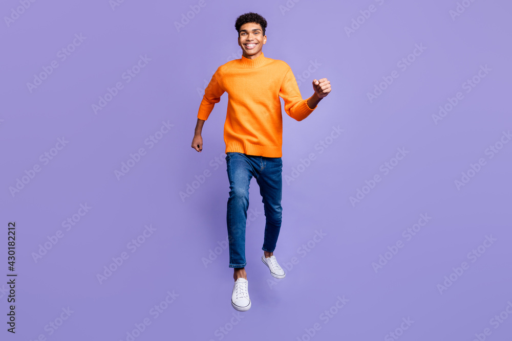 Full body photo of handsome afro american young man walk jump up sale isolated on purple color background Full body photo of handsome afro american young man walk jump up sale isolated on purple color background