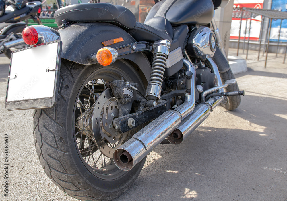 chopper, a motorcycle of high power, in black stands on the asphalt, a view from the back and defocus into the depth of the frame chopper, a motorcycle of high power, in black stands on the asphalt, a view from the back and defocus into the depth of the frame