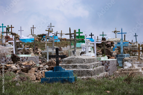 A view of Crosses above graves at a cemetery in a village.