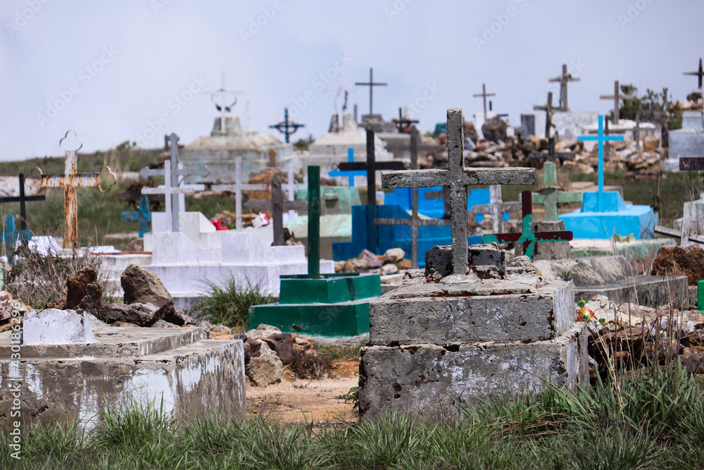 A view of Crosses above graves at a cemetery in a village.