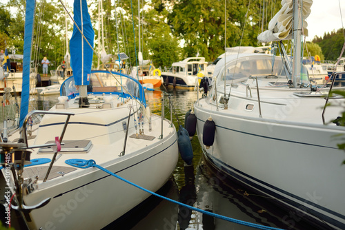 Elegant and modern sailboats moored to a pier in a yacht marina. Slandökalv, Mälaren lake, Sweden. Summer vacations, tourism, yachting, recreation, sport, leisure activity, racing, regatta, lifestyle photo