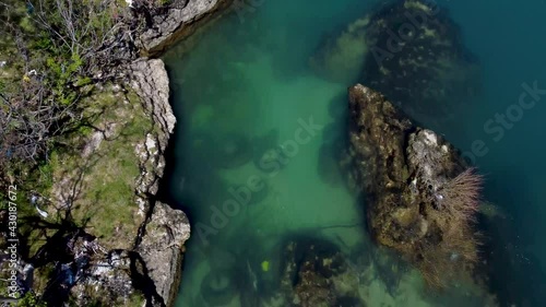 Arial drone view of polluted river. Old car tires and plastic trash thrown in the clean river. Wild garbage dump. Environmental pollution. Water pollution.	
