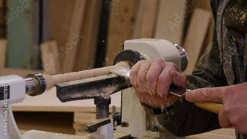 Close up. Carpenter at workshop polishes wooden board with a electric orbital sander. Woodwork and furniture making concept. photo