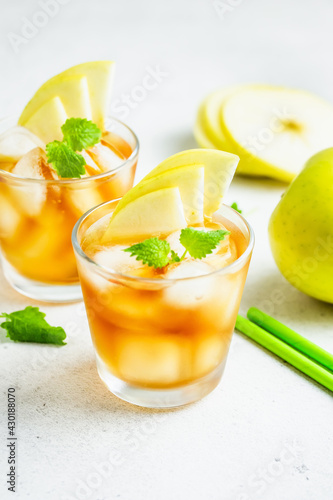 Apple summer refreshing ice mocktail, apple iced tea in glasses. Space for text.