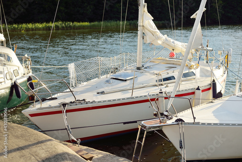 32 feet swedish built cruising sailboat moored to a pier in a yacht marina. Mälaren lake, Sweden. Summer vacations, tourism, yachting, recreation, sport, leisure activity, lifestyle, service photo